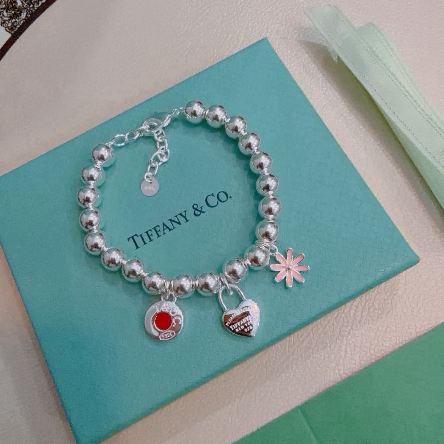 Tiffany & Co. Sterling Silver Bead Bracelet with Lock and Flower Charms